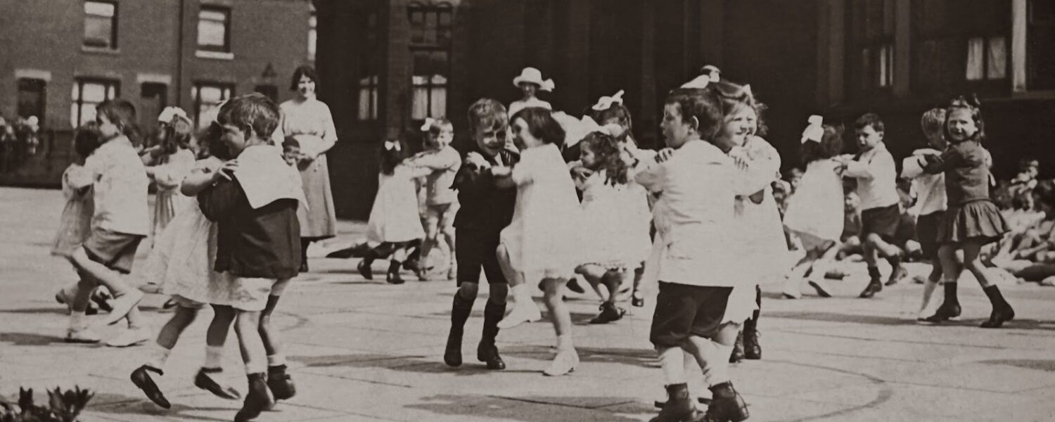Grayscale Photo of Children Dancing on School Ground