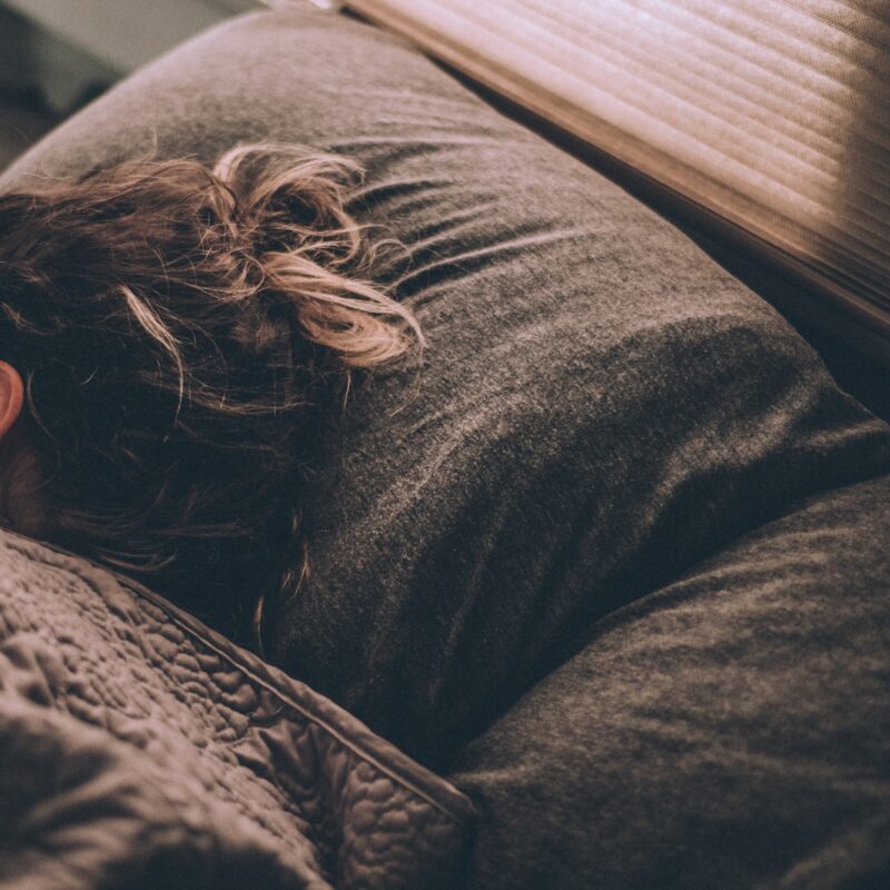 woman sleeping on bed under blankets