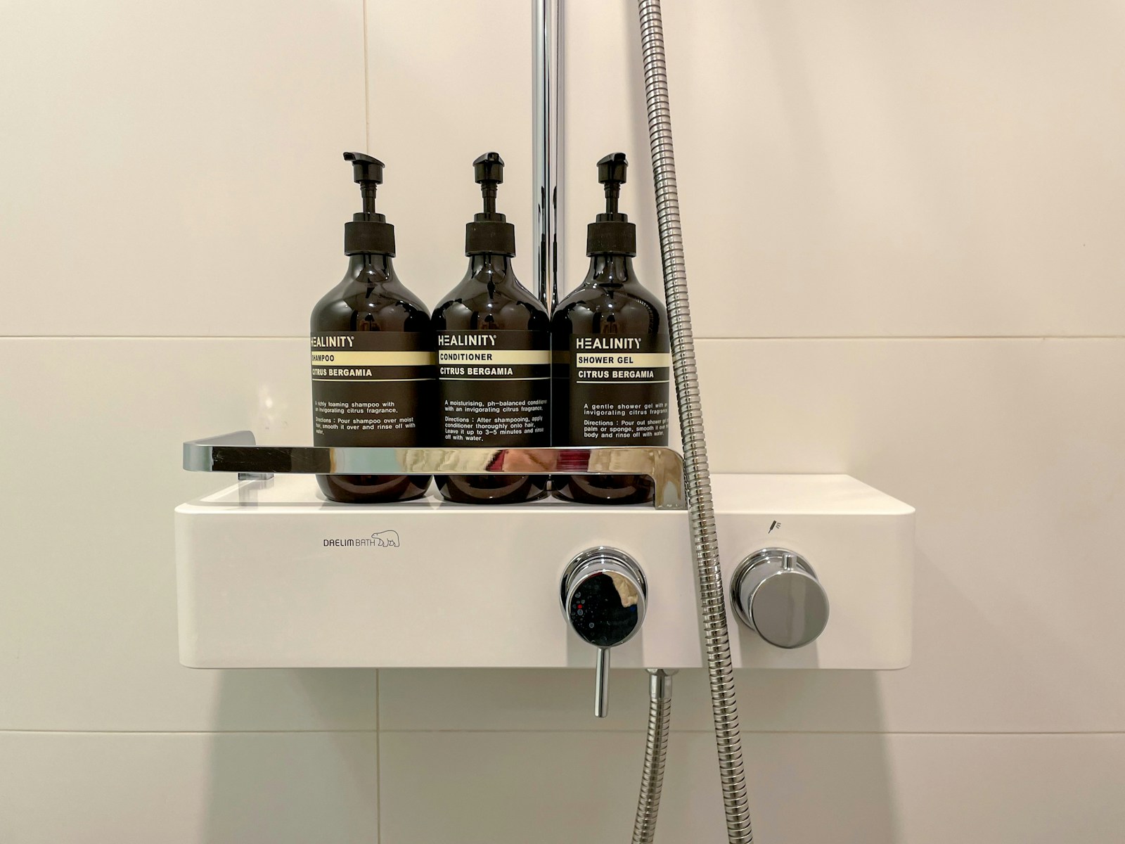 three bottles of shampoo sitting on top of a sink