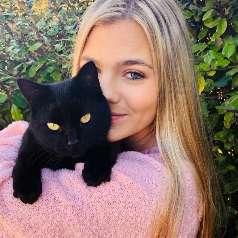 woman with black cat on her lap