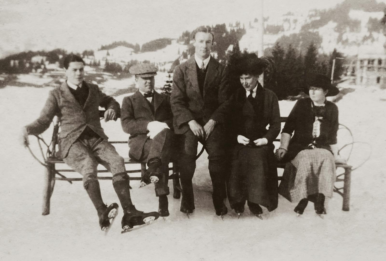 A vintage photo of a family group ice skating outdoors in winter.