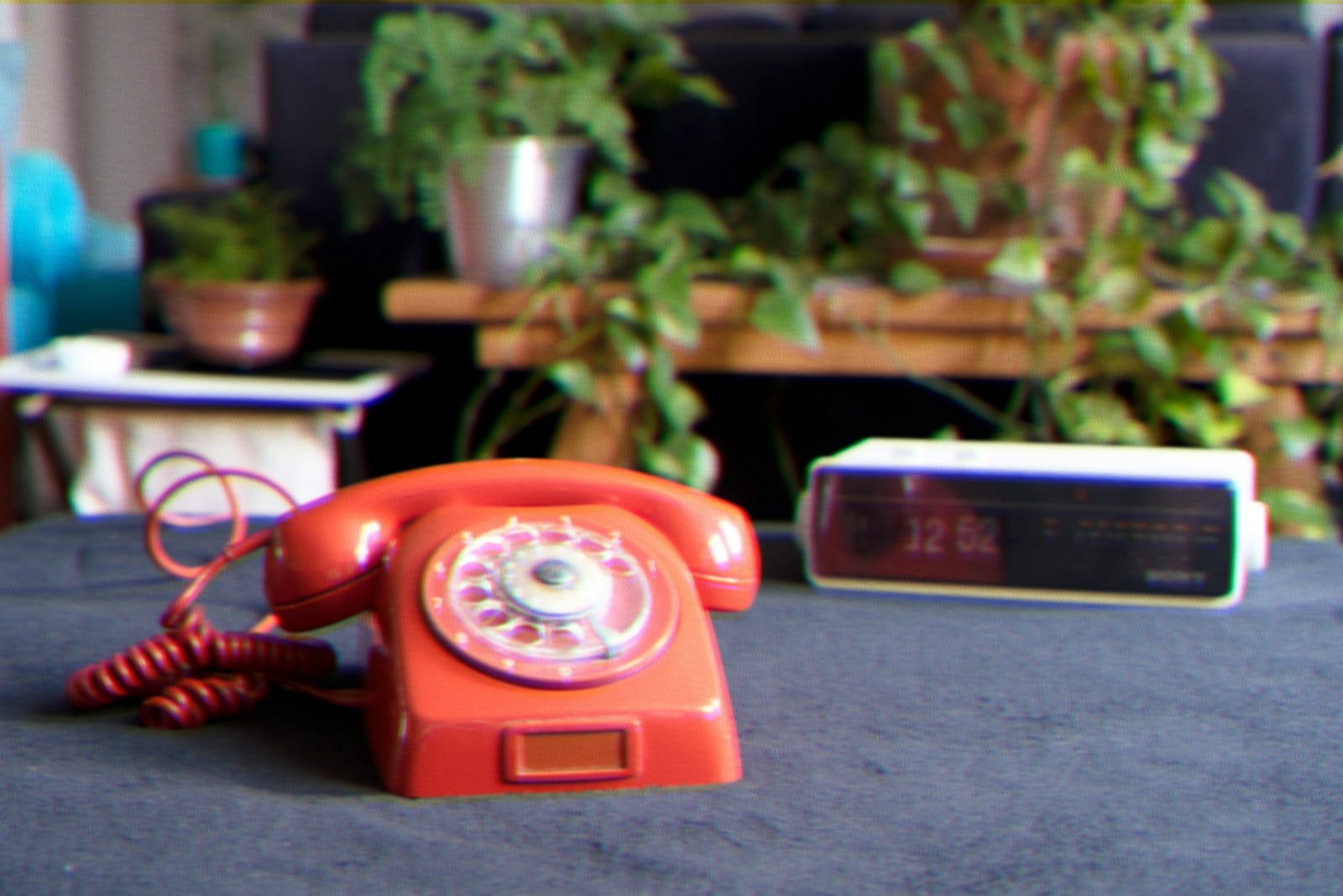 red rotary telephone on gray concrete floor